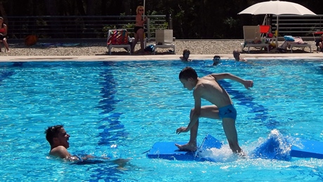A child playing on a floating mat in a swimming pool
