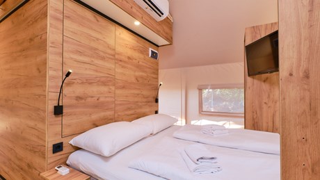 Glamping Premium Tent slaapkamer met tweepersoonsbed een TV