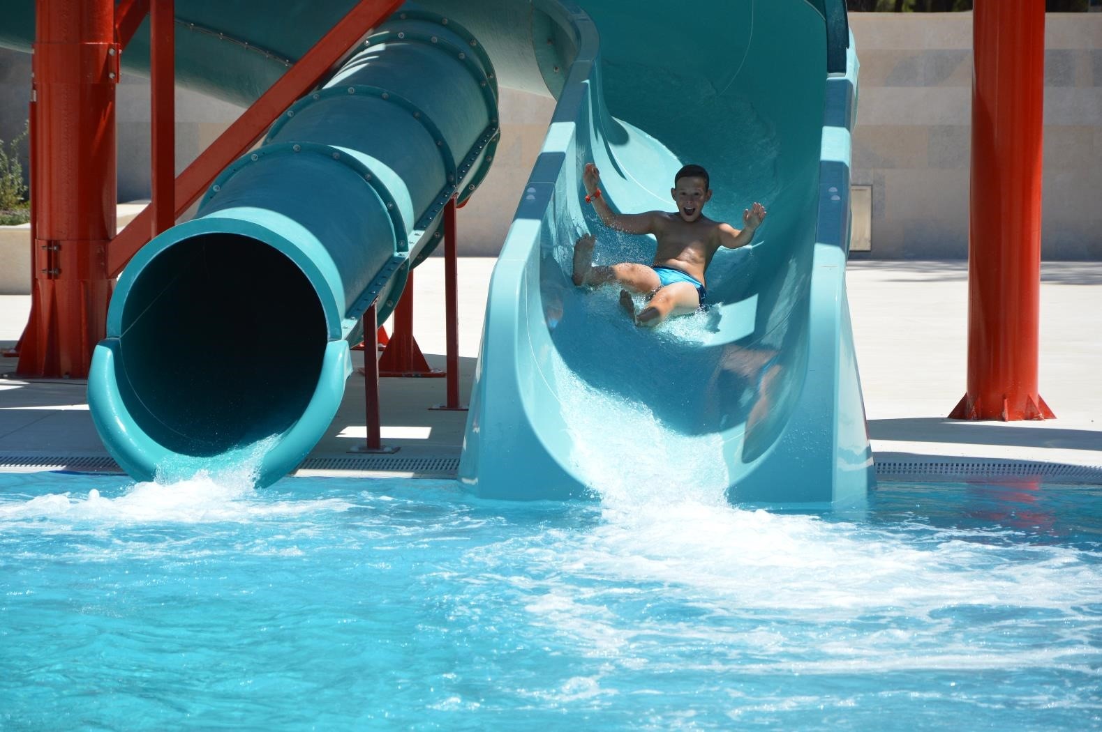 Person sliding down a water slide into a pool